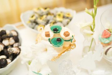 Delicious and tasty dessert table with cupcakes shots at reception closeup