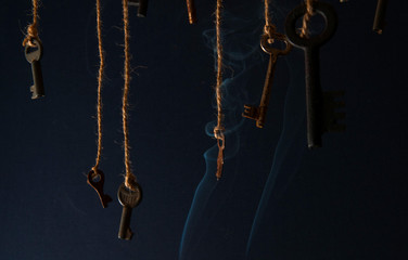 Fototapeta na wymiar Keys hanging on a string. Smoke background. Selective focus