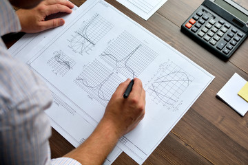 Mechanical engineer at work. Technical drawings. Paper with technical drawings and diagrams.