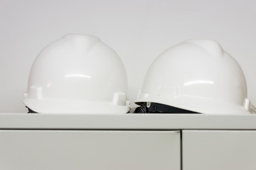 Two white plastic safety helmet in a construction office of an architect