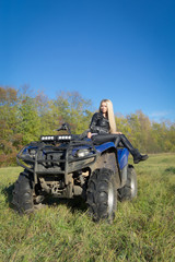 Fototapeta premium Elegant blonde woman riding extreme quadrocycle ATV on summer fi