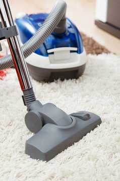 Vacuum cleaner on shaggy carpet inside room