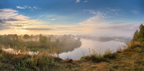 Naklejka na ściany i meble Foggy river in the autumn morning