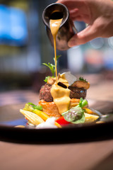 Waiter puring sauce on foie gras veal © lmanju