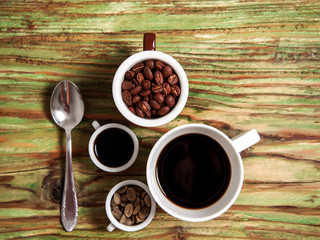 coffee bean in cups and spoon on table
