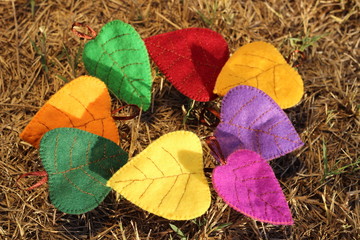 Multicolored autumn leaves from textile fabric on dry grass background