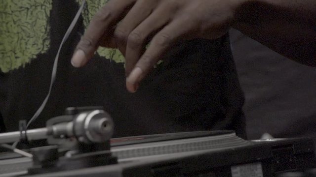 Black DJ hand scratching a vinyl on a turntable. 200 fps slow-motion motion, SLOG3, Close up.