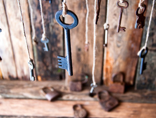 Many keys hanging on a string. Wooden background. Selective focus