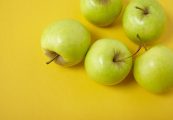 Green apples on a bright yellow background forming a page border