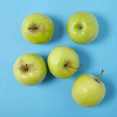 Aerial view of green apples on a bright blue background