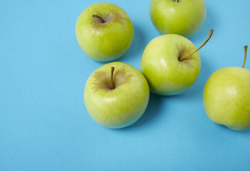 Green apples on a bright blue background forming a page border