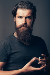 bearded man with glass of brandy or whiskey