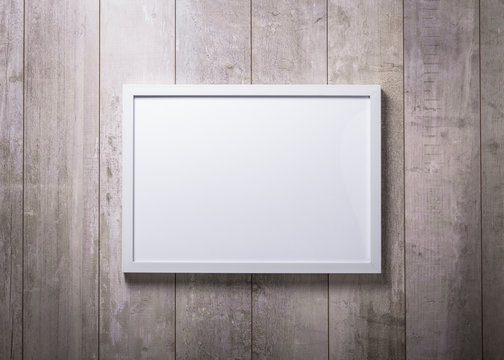 Blank white picture frame on the wood wall
