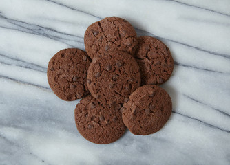 Aerial view of a pile of chocolate chip cookies on a marble counter top background