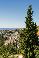 Fototapeta na wymiar Sunny view of Granada from viewpoint of garden of Generalife, Andalusia province, Spain.