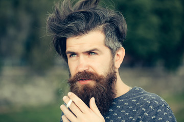 bearded man smoking cigarette outdoor