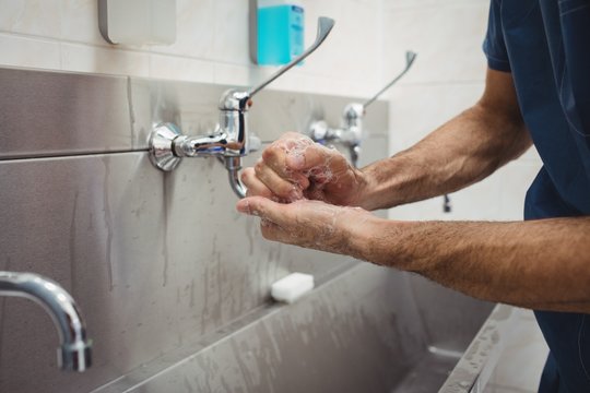 Male surgeon washing his hands
