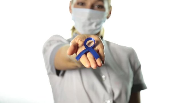 Close-up of female doctor hands holdingdark blue ribbon to support the fight against tuberculosis, sexual slavery and human trafficking. healthcare and medicine concept.