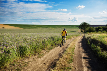 Fototapeta na wymiar Young man cycling on a rural road