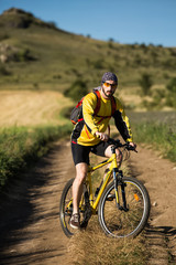 Fototapeta premium Young man cycling on a rural road