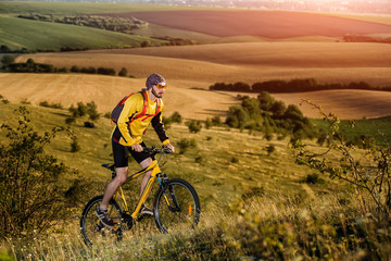 Fototapeta premium Young man cycling on a rural road