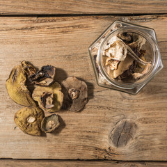 Dried mushrooms in a jar on a wooden table