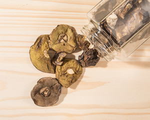 Dried mushrooms in a jar on a wooden table
