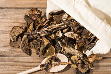 Dried mushrooms in a sack on a wooden table