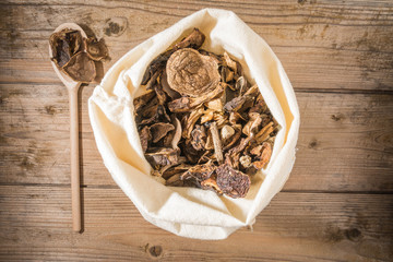 Dried mushrooms in a sack on a wooden table