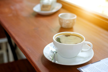 White coffee cup on wooden floor.