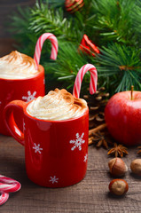 Hot chocolate with whipped cream in red cups. Christmas composition. Selective focus.