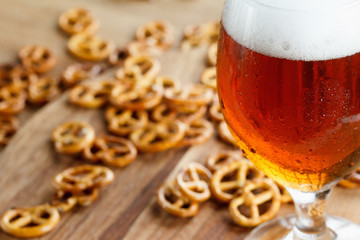 Glass of cold foamy beer with german brezel