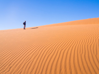 Fototapeta na wymiar Single man walking on the Namib Desert