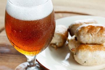 Traditional homemade sausage with beer on wooden table