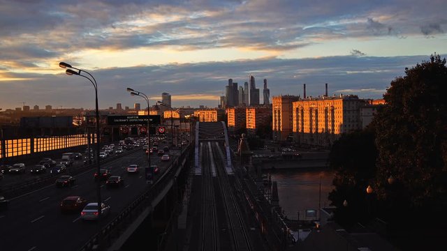 The skyscrapers, the Third Ring Road and the ES2G Lastochka (Swallow) trains on the Moscow Central Circle line at sunset. UHD - 4K. September 14, 2016. Moscow. Russia