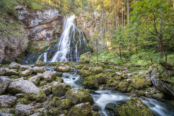 Waterfall with stream in idyllic forest