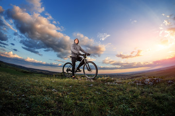 Fototapeta na wymiar Young man cycling on a rural road through meadow
