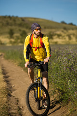 Fototapeta na wymiar young bright man on mountain bike