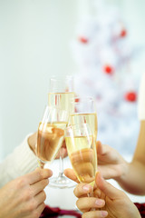 Close-up of hands clinking champagne glasses