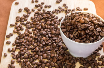 Coffee Cup with coffee beans on wood of coffee beans background.