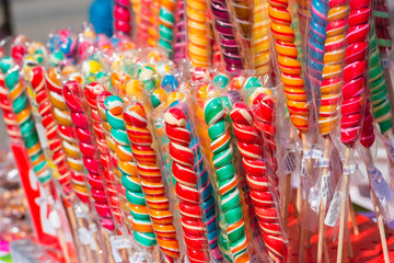Fototapeta na wymiar Colorful handmade swirl lollipops on street market