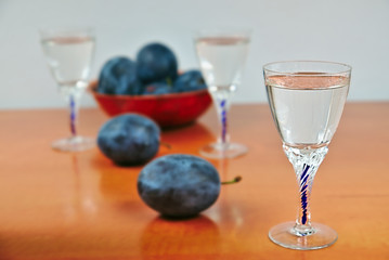 Glasses of homemade plum brandy with plums