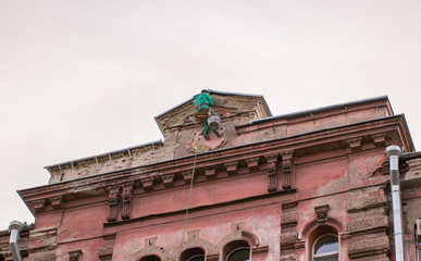builder-climber hanging on the top of the facade a building