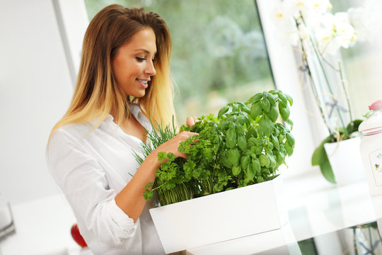 Young Woman With Herbs In Kitchen