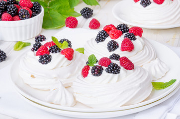 Meringue cakes Pavlova with whipped cream and fresh berries