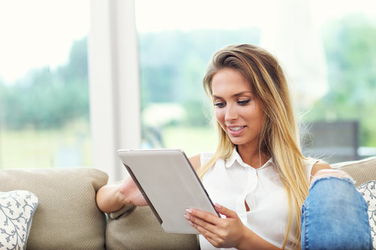 Woman On Couch With Tablet In Living Room