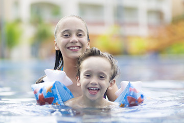 Happy Girl and Boy Enjoying in Swimming Pool