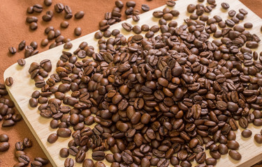 Coffee beans pile on a wooden floor. Selective focus.

