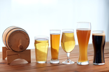 close up of different beers in glasses on table