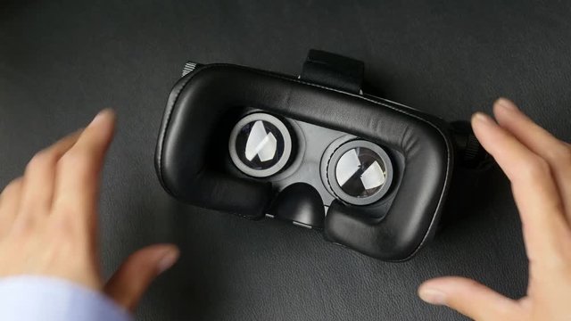 Male hand taking a virtual reality headset.